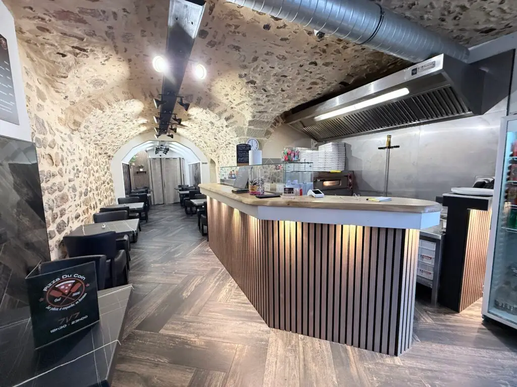 Intérieur de la Pizzeria Crest – Pizza Du Coin avec pierres apparentes, four à pizza et ambiance chaleureuse